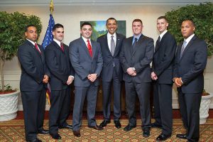 In 2011, Flores (wearing a red tie and standing next to the president), served on President Obama's private security detail in Central and South America, including a visit to Flores' native El Salvador. 