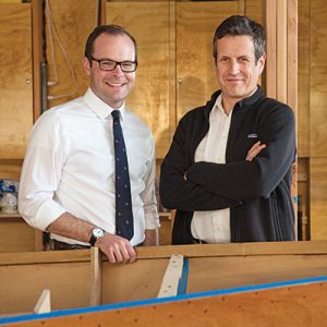 Fordham alumni Alex Baum (left) and Robert Burke in the Hudson River Community Sailing boathouse on Pier 66 in Manhattan. Burke is the nonprofit's executive director, and Baum heads the group's youth programs. Photo by Bud Glick