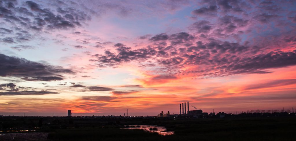 evening sky in an industrial area. Sky is blue and orange.