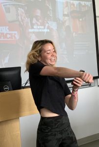 Young woman dancing and performing in front of a projector