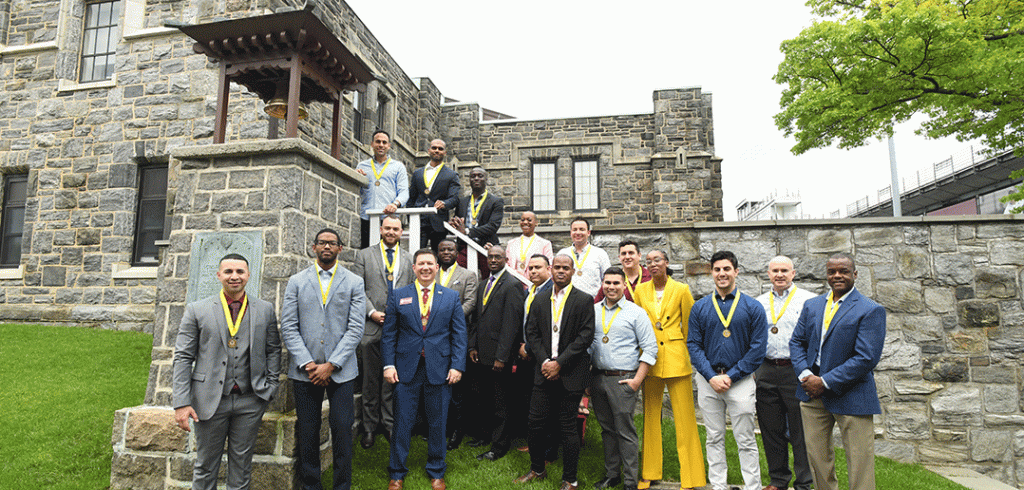 A group photo of student veterans next to the Victory Bell