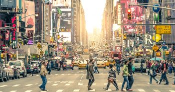 People walk across a street in New York City