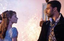 A woman in a man stare at each other in front of a background filled with sparkles.