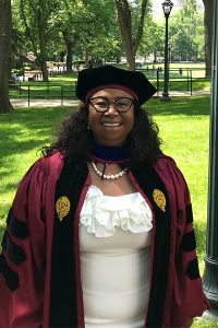 Magalie Exavier-Alexis, a 2021 GSE graduate, posing with trees in the background.