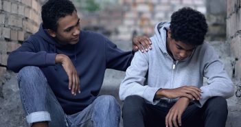 Afro-american teenager trying to make peace with friend, helping boy in need
