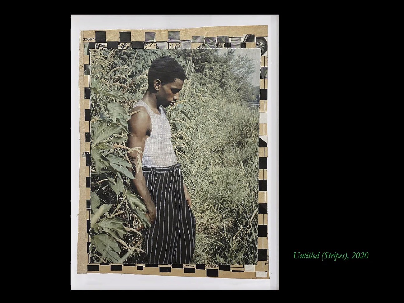 A photo of a Black man surrounded by grass