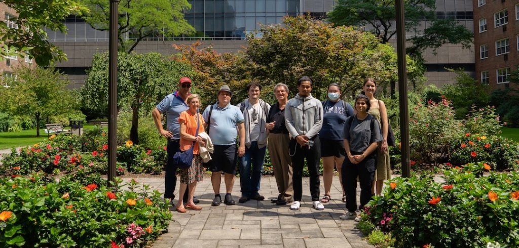 A group of people stand in the middle of a garden together.