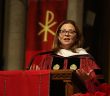 President Tetlow in academic robes speaking on altar
