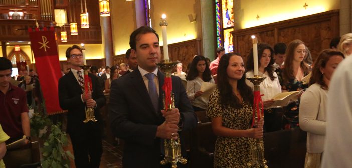 Student leaders process in church with candles