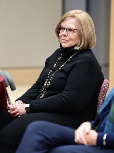 A woman sits and listens.