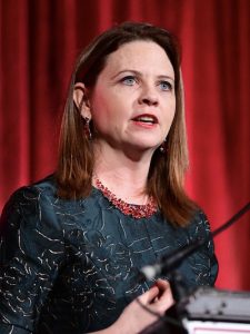 A woman speaks at a podium.