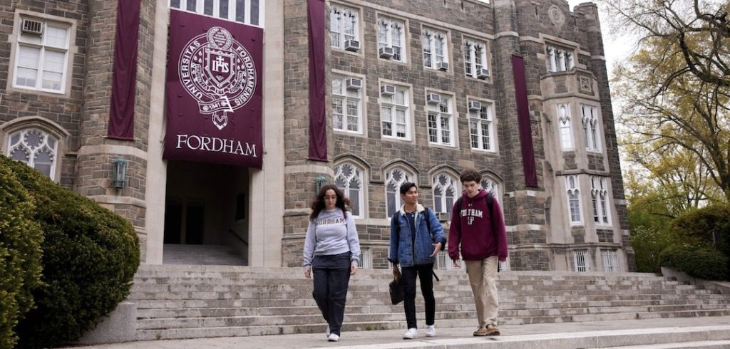 Three Fordham students walk in front of Keating Hall.