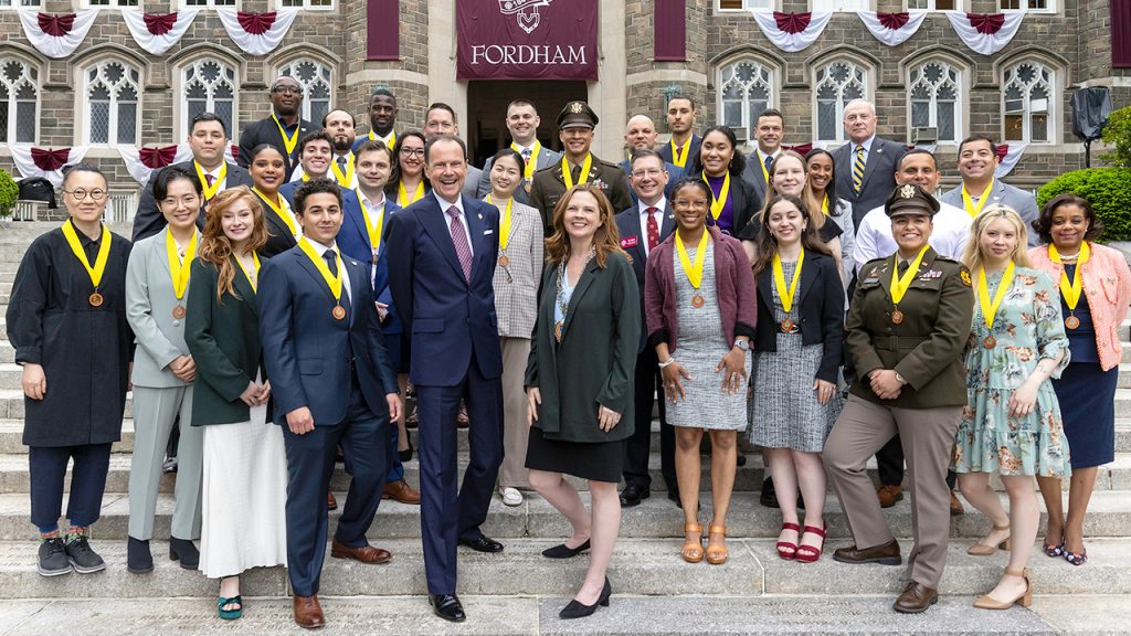 Group photo of student veterans and others, including Fordham President Tania Tetlow, at Fordham's Yellow Ribbon Medallion and Bell Ringing Ceremony