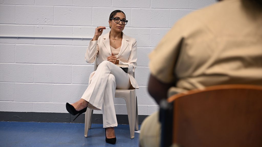 Choose Hope: Why I Returned to Rikers Island Afrika Owes, wearing a white pantsuit, speaks with women incarcerated at Rikers Island.