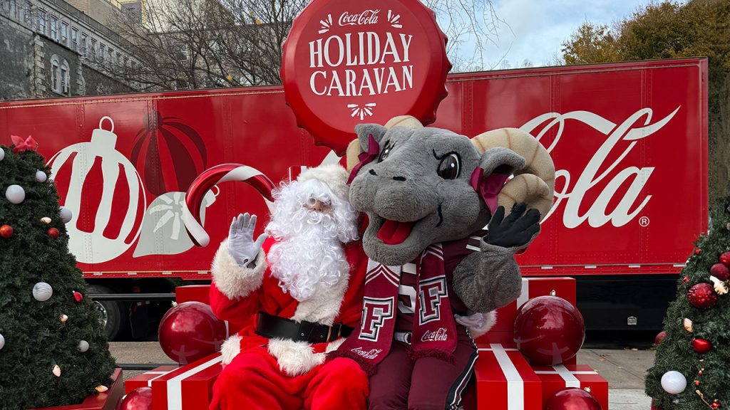 Ramses and Santa posing in front of the Coca Cola caravan.