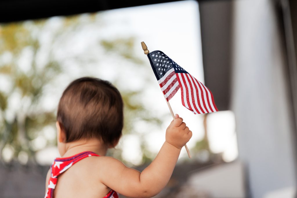 A baby holds a small American flag, representing Trump's executive order aimed at ending birthright citizenship in the United States