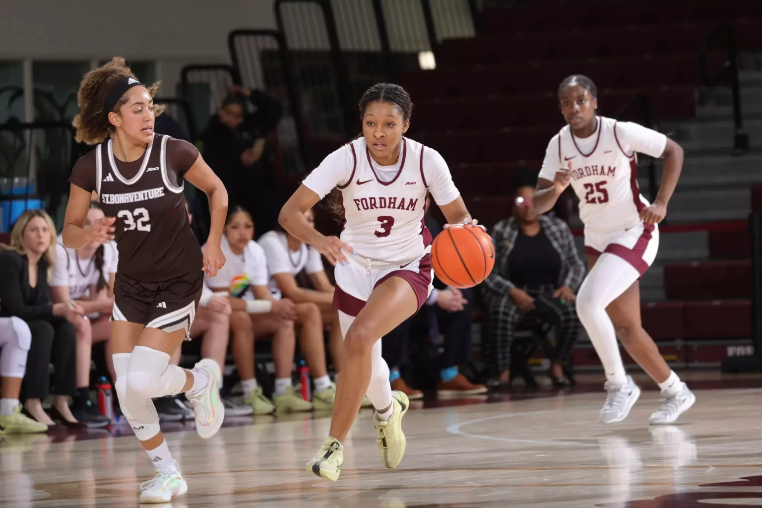 3 women playing basketball on court