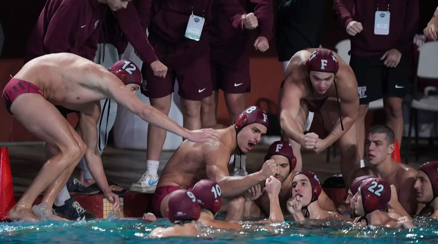 Men's water polo team together in uniform, in pool