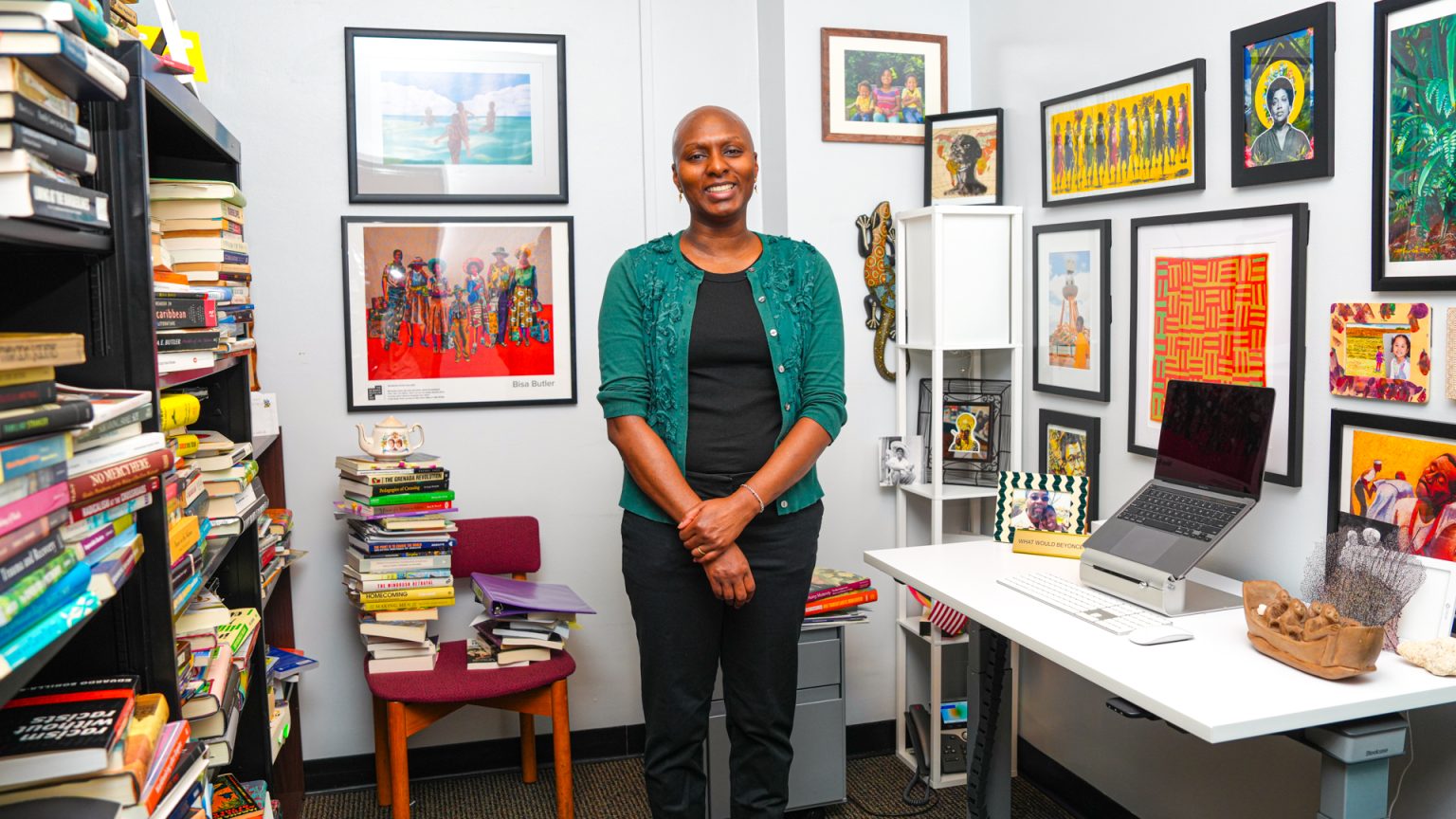 Laurie Lambert stands and smiles in the center of her office.