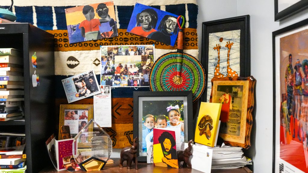 A collection of artwork and photos surrounding a bookshelf