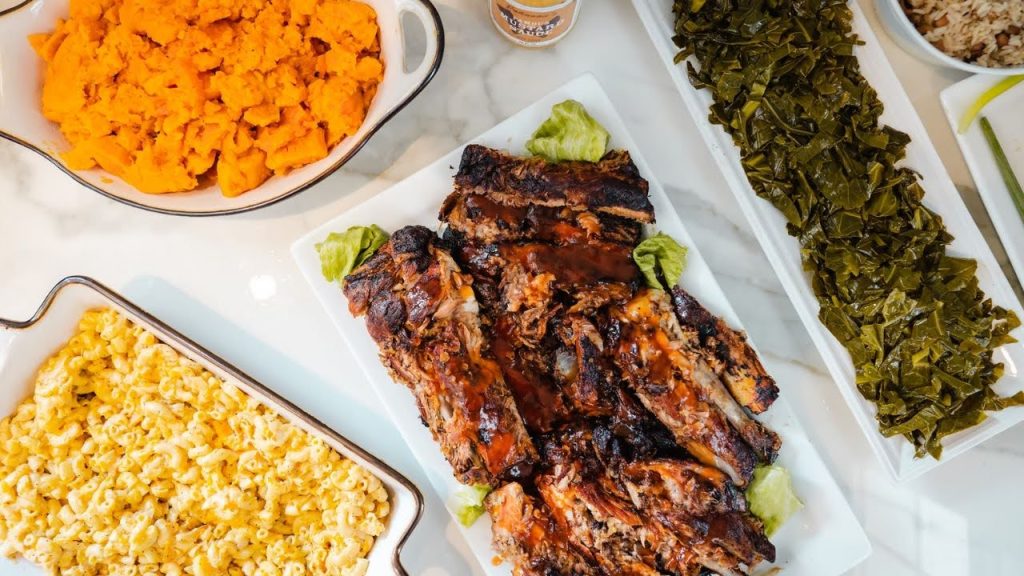 A photo of ribs, collard greens, mac and cheese, and sweet potatoes from Johnson's Bar-B-Q in the Bronx. 