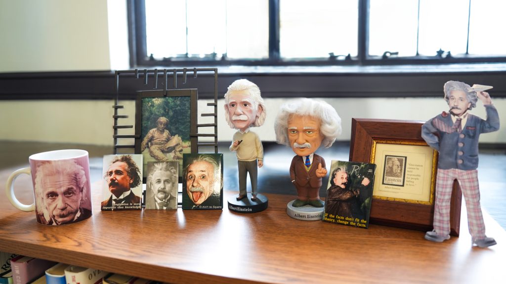 A collection of Einstein memorabilia on a bookshelf