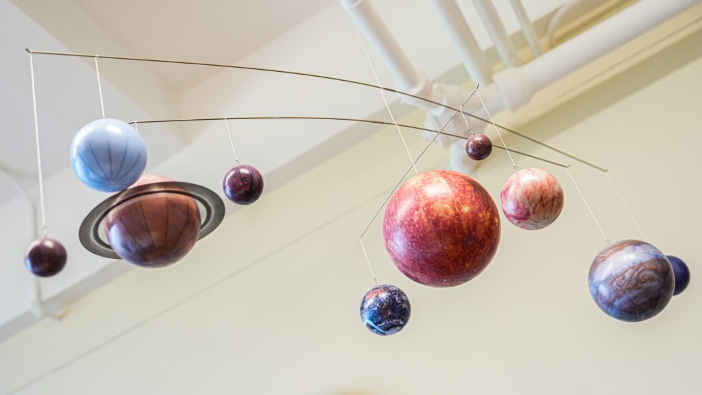 A mobile of our solar system hanging from the ceiling