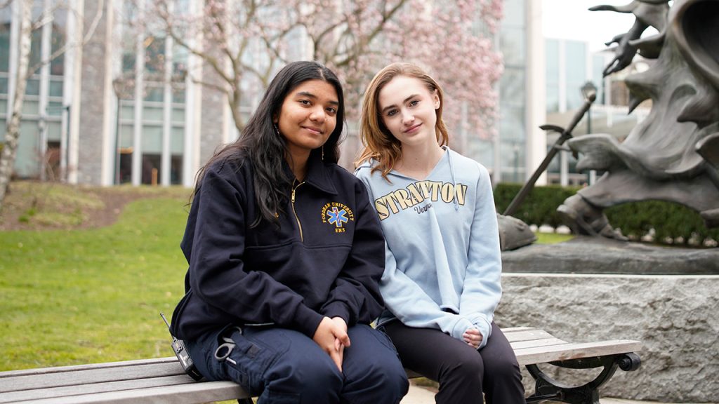 Two women sitting together on a bench