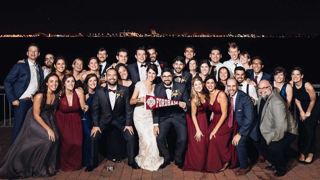 group wedding photo with skyline at night