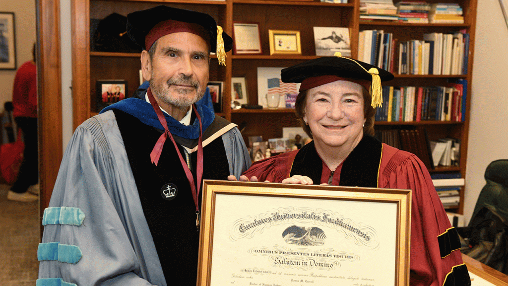 A woman poses holding a diploma standing next to a man