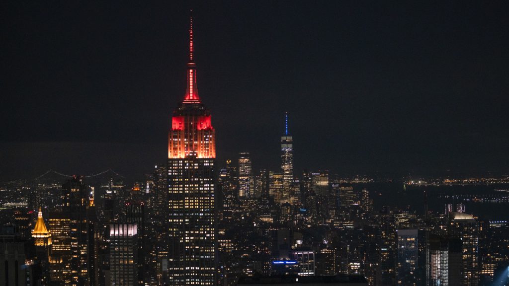 The Empire State Building lit in maroon at night