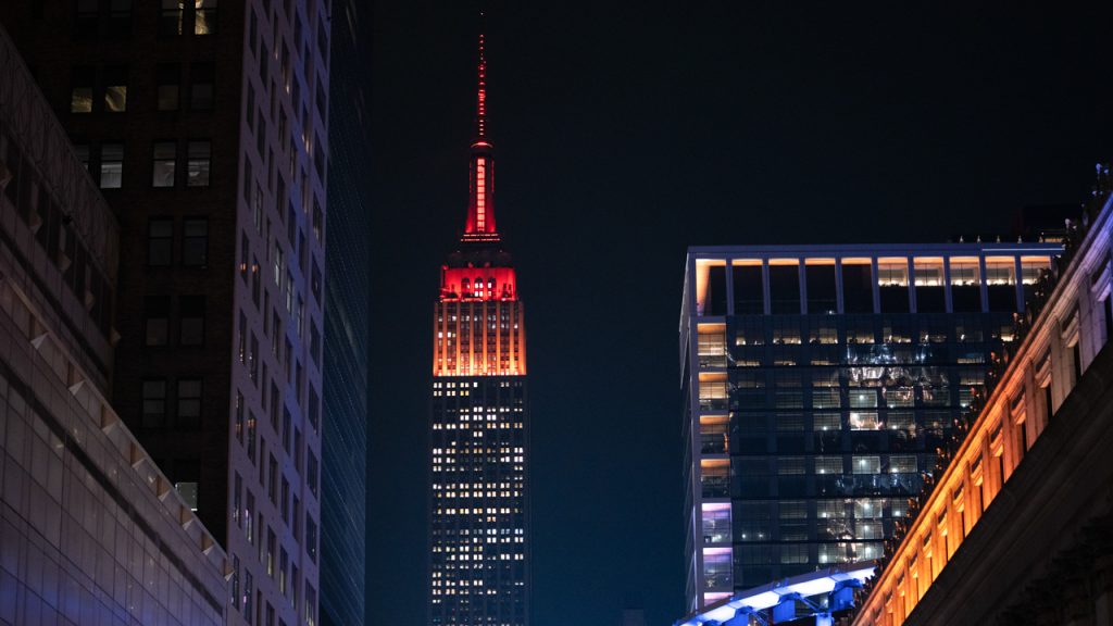 The Empire State Building lit in maroon at night