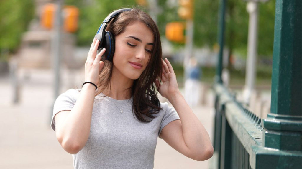 Fordham Vibes: AI Playlist by Comp Sci-Math Grad A woman holds onto headphones on her head while her eyes are closed
