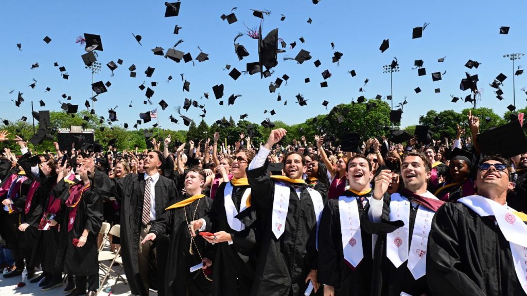 students toss their graduation caps