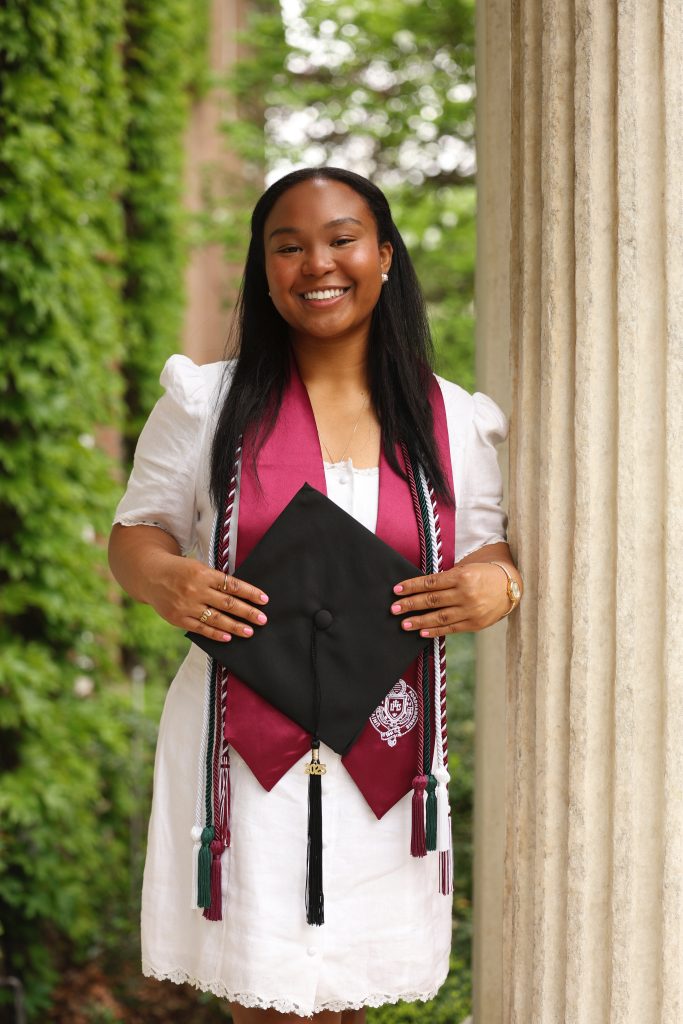 A photo of Fulbright recipient Jacqueline Adigwu posing in her Fordham graduation outfit.