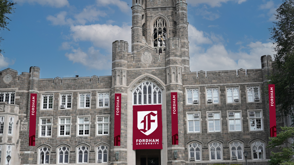 A photo of Fordham's Keating Hall with banners bearing the new logo and wordmark, representing Fordham's 2025 brand evolution.
