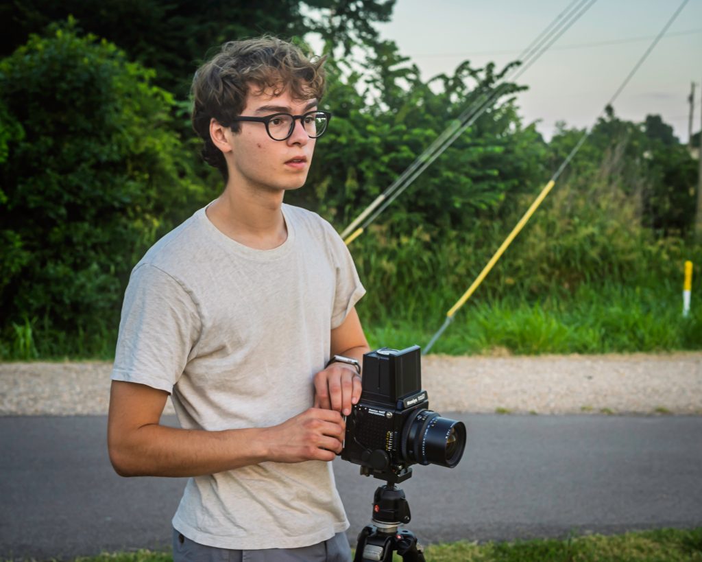 Milo Powell, Fordham graduate and Fulbright recipient, poses behind a camera