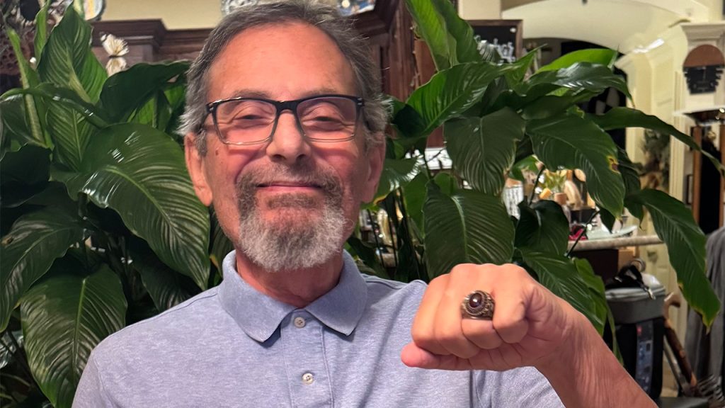 Al DiStefano with his left hand raised in a fist to show his class ring.