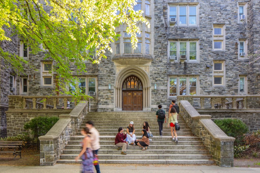 Students sit on stone steps