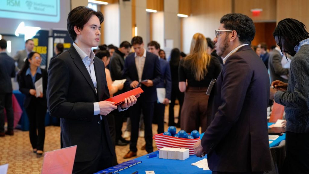 A student speaks with a recruiter at a Fordham Career Fair, representing job search tips for recent graduates