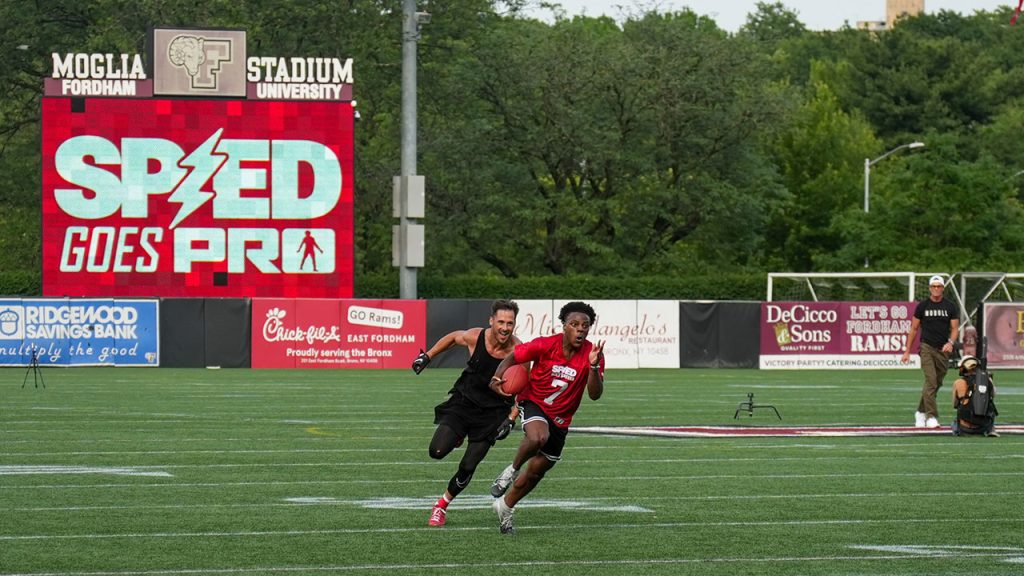 Speed runs with a football down a field as Danny Amendola chases him and Tom Brady looks on.