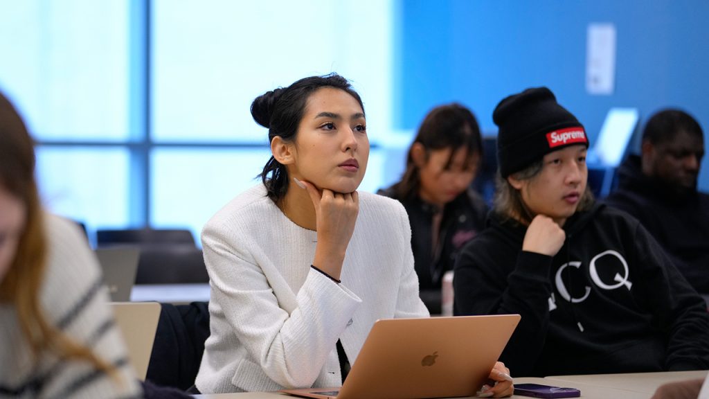 A woman with laptop in front of her looks up
