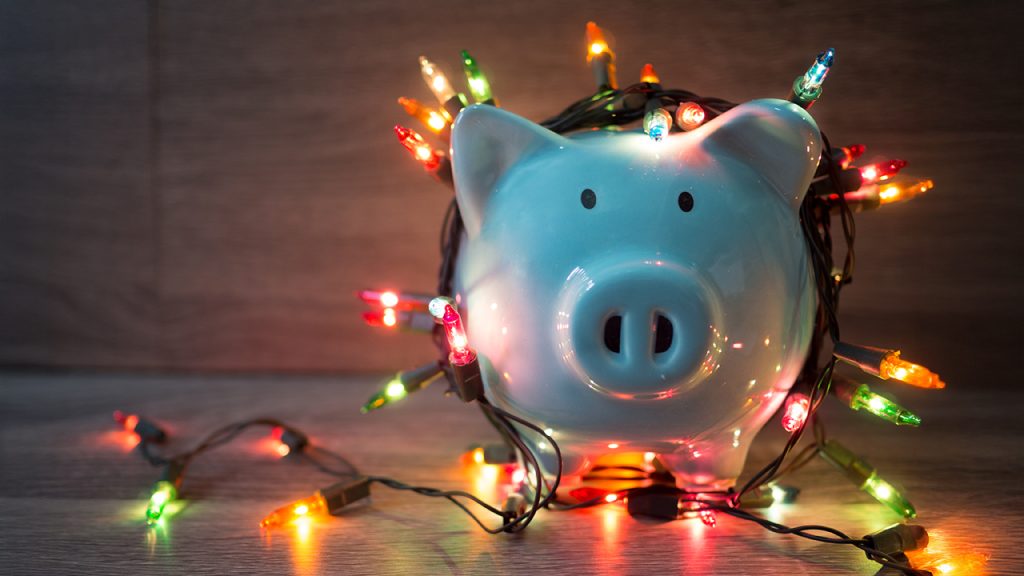An image of a piggy bank draped in Christmas lights