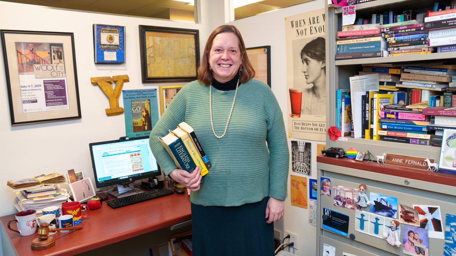 Anne Fernald stands in the middle of her office and smiles at the camera.