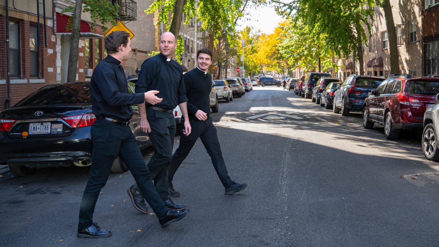 Jesuit scholastics walk outside of Ciszek Hall